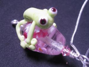 One of my cute glass frogs on a pink bead, hanging on a silver necklace.